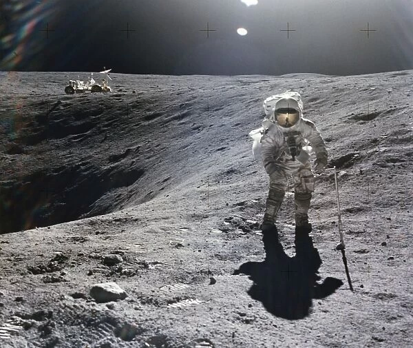 APOLLO 16, 1972. Astronaut Charles M. Duke collecting lunar samples at the rim of Plum Crater during the Apollo 16 mission, 21 April 1972. Photographed by astronaut John Young