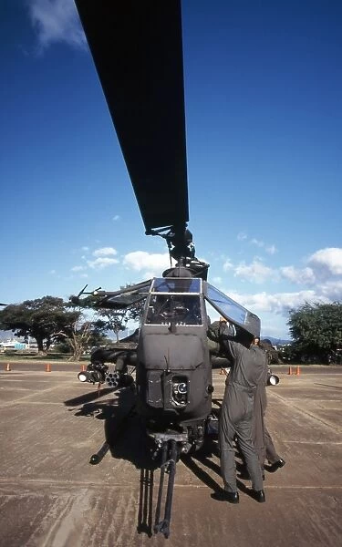 Air crewmen secure an AH-1 Cobra attack helicopter