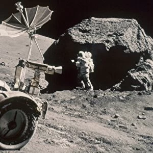 APOLLO 17, DECEMBER 1972: Front of Lunar Rover and Schmitt working by large boulder